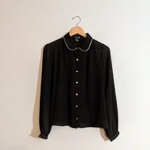Black blouse with gold accents.